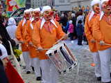 Carnival of Basel 2009, Drummers, with a naive grin on their face, a red nose, big teeth, orange shirt, white trousers, white night cap