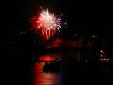 Firework on the Rhine 2006, red white and blue flowers, behind the Johanniterbruecke and many boats, eve of 1st August, Basle, Switzerland