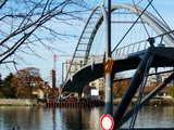 Die Dreiländerbrücke, 8 Tage nach der Aufstellung, Montag 20 Nov 2006, in Weil am Rhein, Deutschland, aufgenommen, am anderen Ufer sehen wir den Glockenturm der Kirche Christ-Roi in Huningue, Frankreich, zahlreiche Vögel haben den oberen Teil der Brücke als Aussichtspunkt ausgewählt