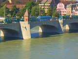 The Rhine in Basle, Switzerland, upstream of the middle bridge, the oldest of the 5 bridges crossing the Rhine in Basle, with the tower built on a pillar of the bridge and 2 trams